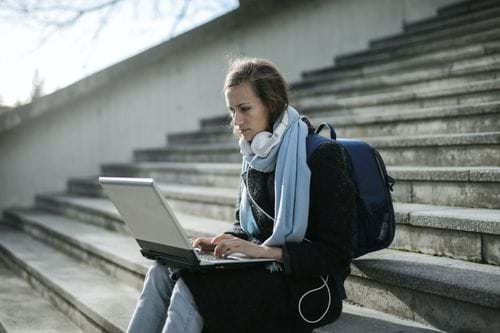 student studying from a laptop on the stairs